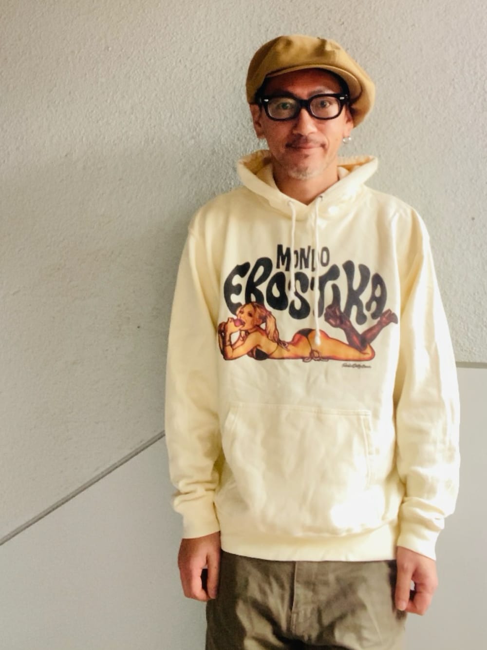 ベージュ系のパーカー、グリーン系のカーゴパンツ、ベージュ系のブーツを着用したメンズの春コーディネートの2枚目の写真