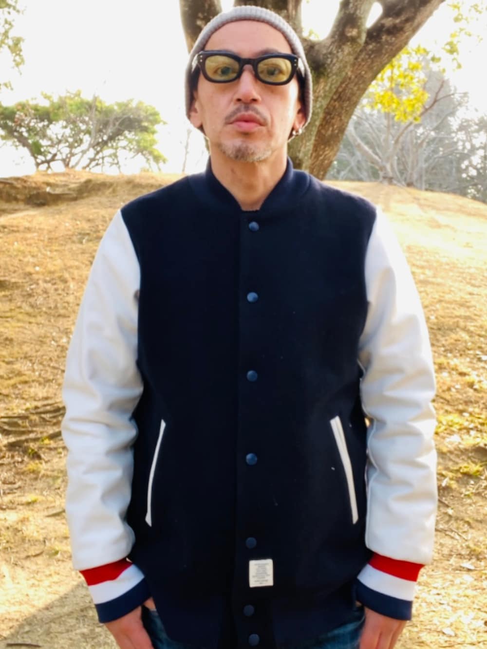 ブラック系のスタジャン、ブルー系のデニムパンツ、ブラック系のスニーカーを着用したメンズの冬コーディネートの2枚目の写真