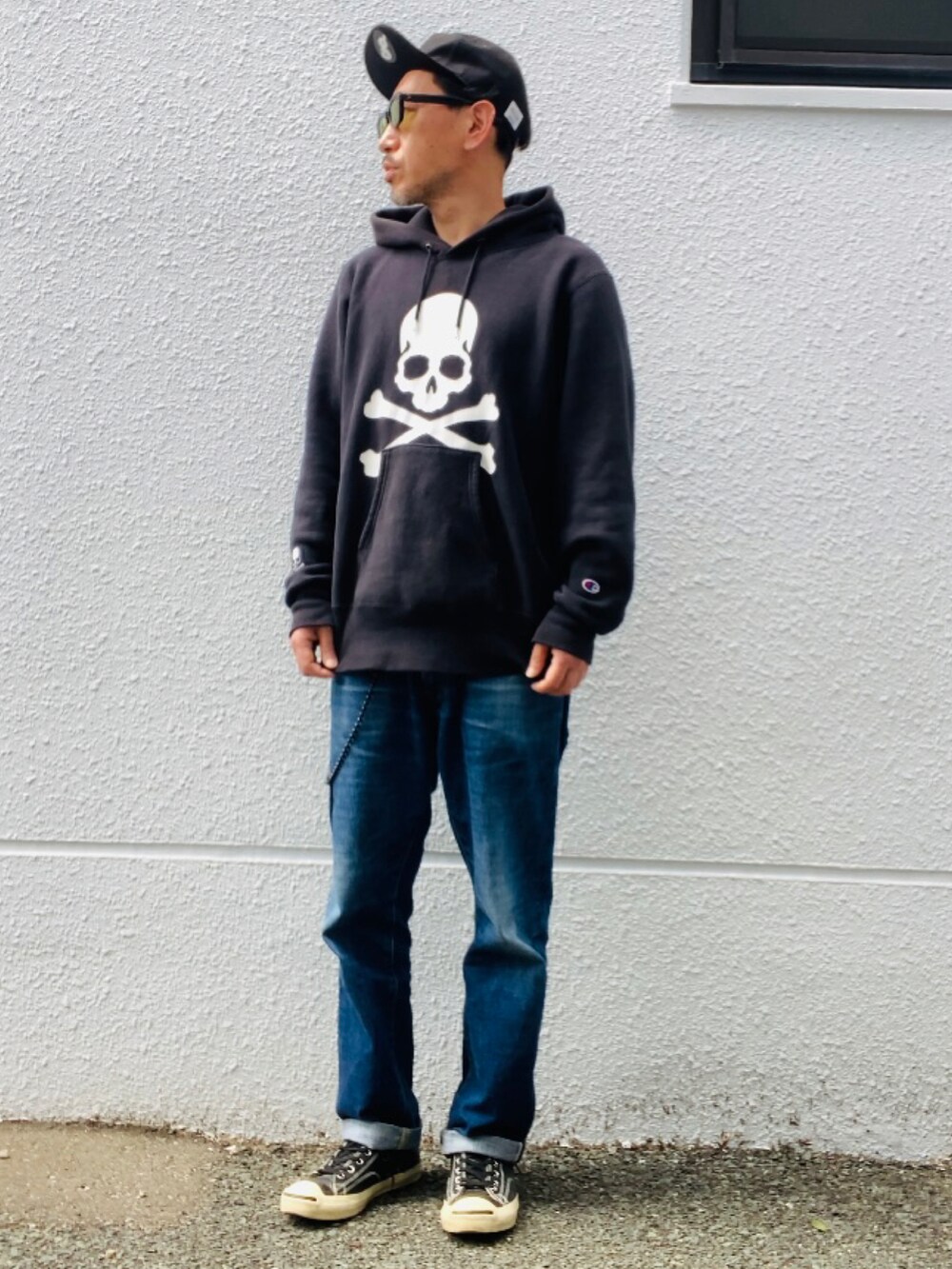 ブラック系のパーカー、ブルー系のデニムパンツ、ブラック系のスニーカーを着用したメンズの春コーディネートの5枚目の写真