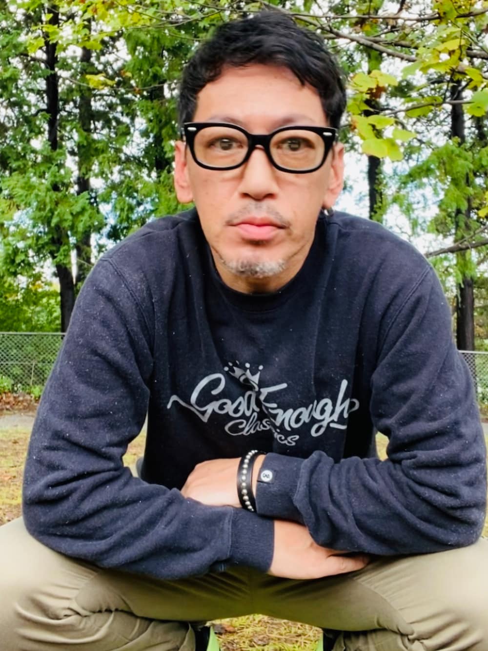 ブラック系のスウェット、グリーン系のカーゴパンツ、イエロー系のスニーカーを着用したメンズの秋コーディネートの4枚目の写真