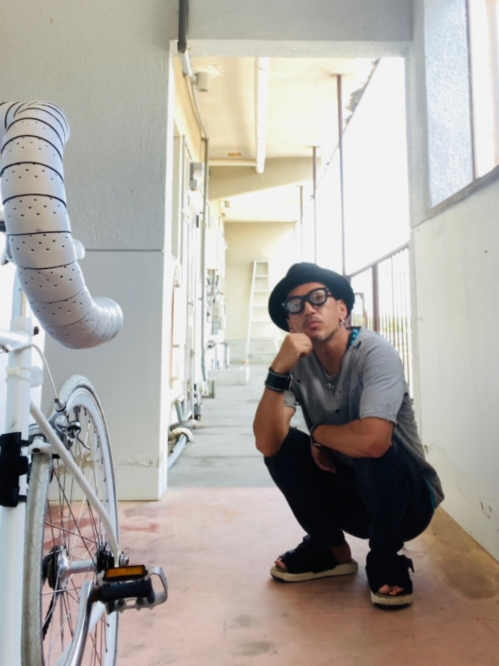 グレー系のTシャツ/カットソー、ブルー系のタンクトップ、ブラック系のデニムパンツを着用したメンズの秋コーディネートの4枚目の写真