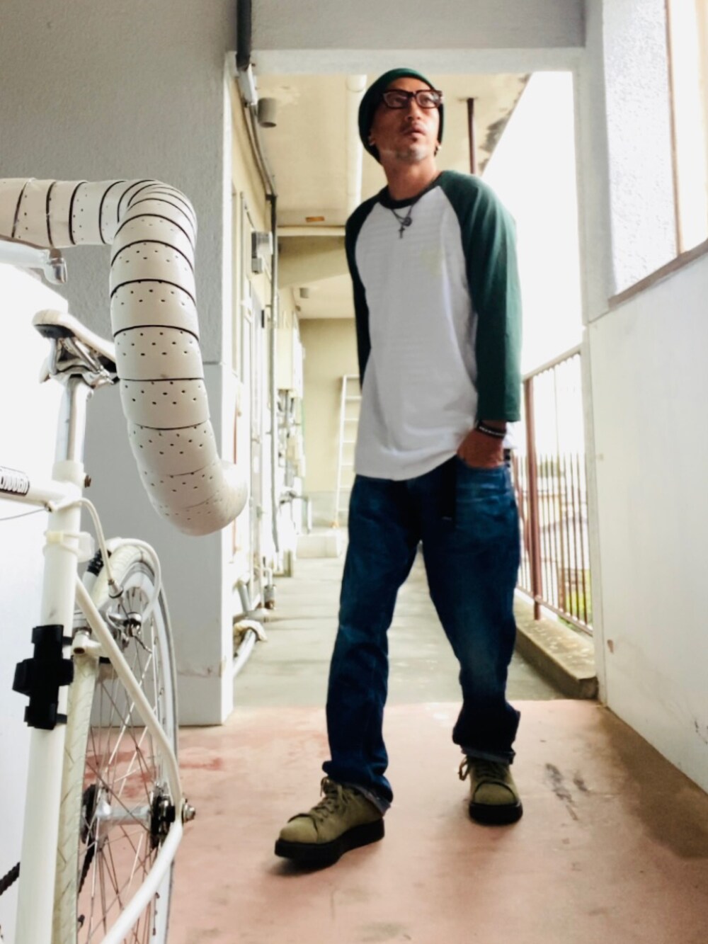 グリーン系のTシャツ/カットソー、ブルー系のデニムパンツ、グリーン系のスニーカーを着用したメンズの秋コーディネートの4枚目の写真