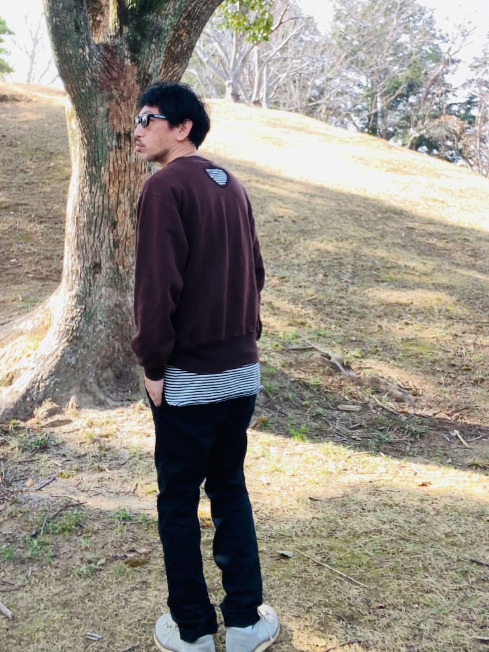 ブラック系のトップス、ブラウン系のスウェット、ブラック系のチノパンツを着用したメンズの春コーディネートの4枚目の写真