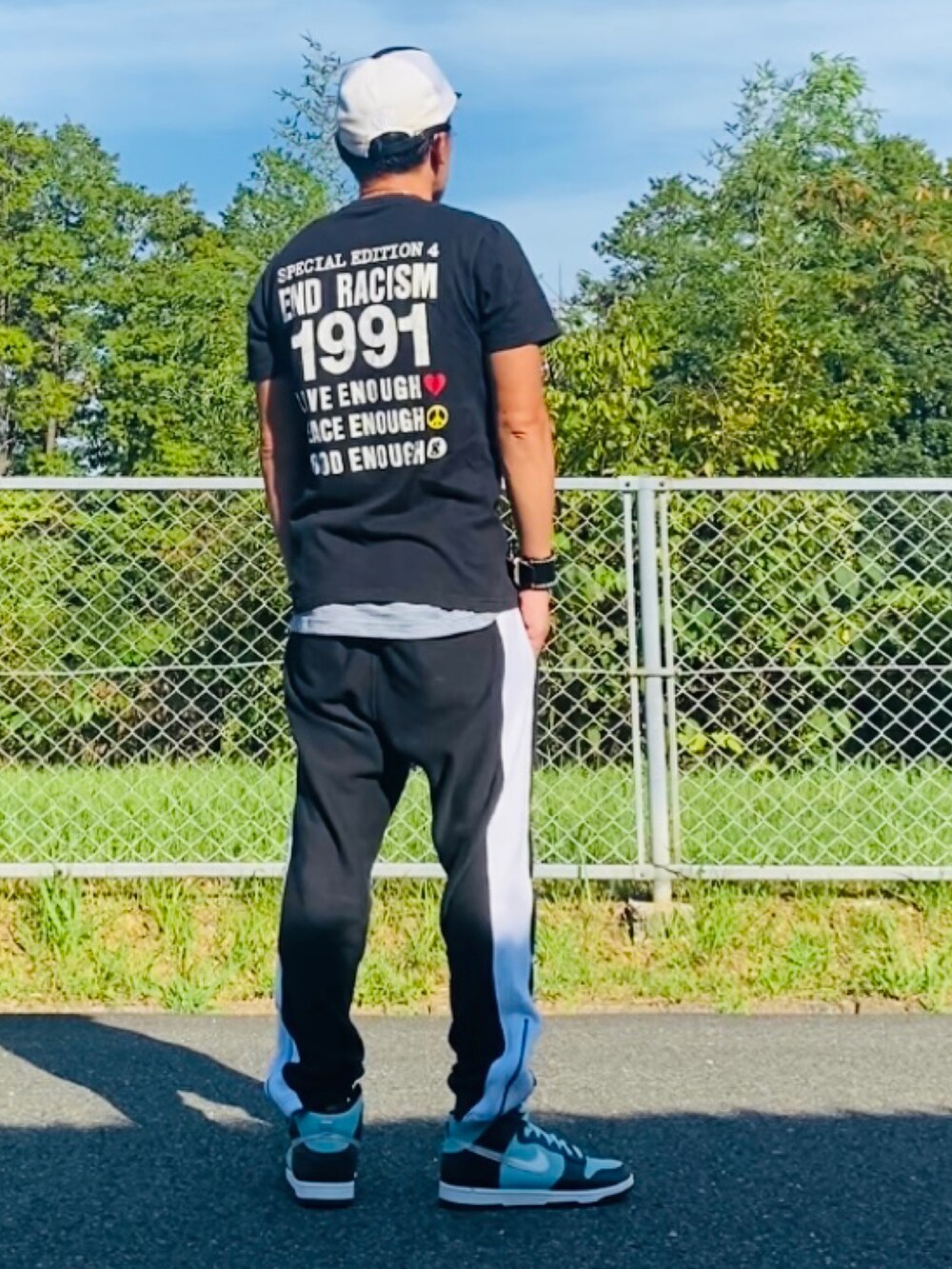 ブラック系のTシャツ/カットソー、ブラック系のスウェットパンツ、グリーン系のスニーカーを着用したメンズの秋コーディネートの2枚目の写真