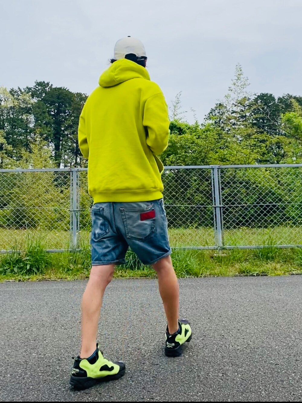 イエロー系のパーカー、ブルー系のその他パンツ、イエロー系のスニーカーを着用したメンズの春コーディネートの3枚目の写真