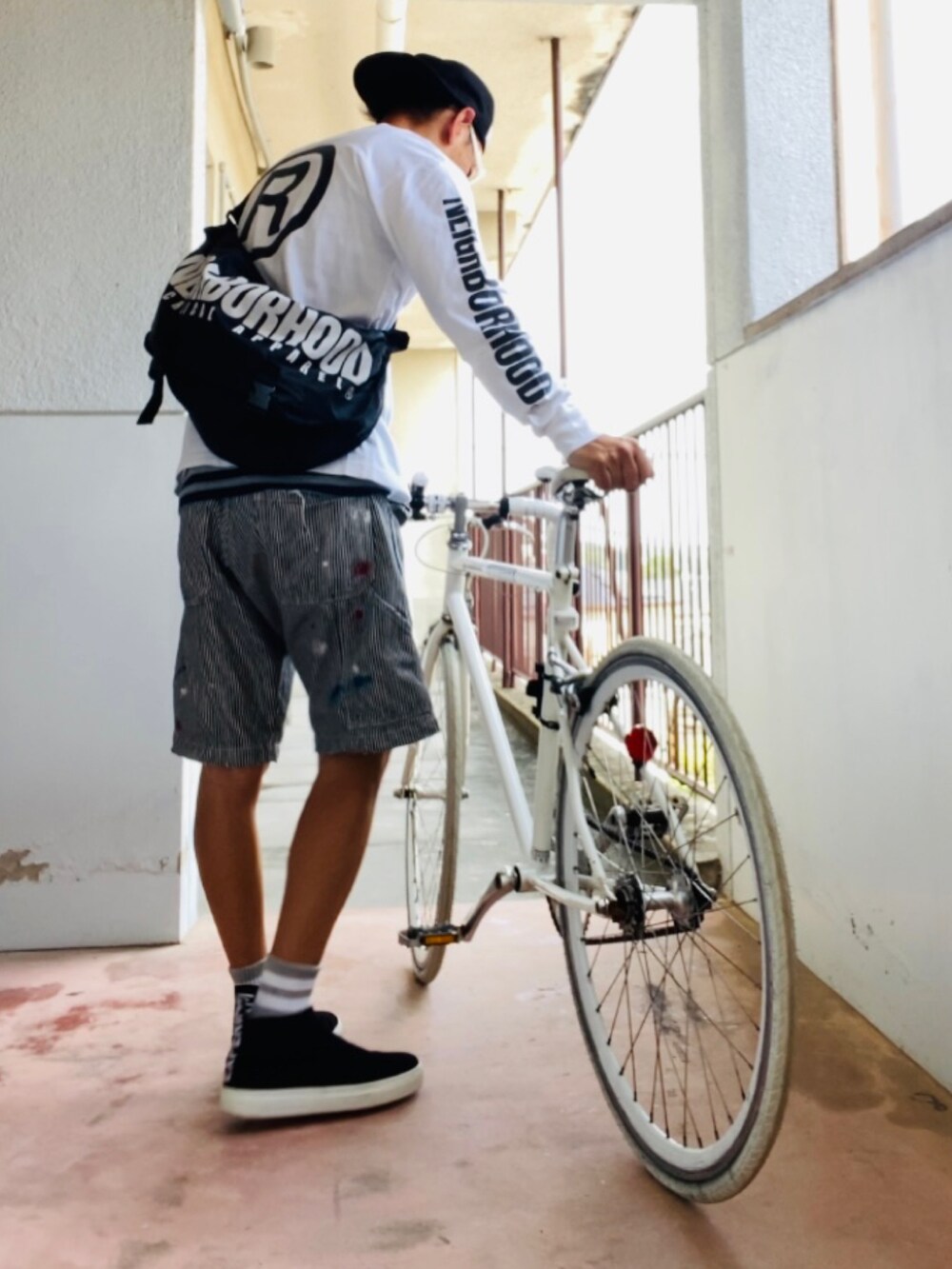 ホワイト系のTシャツ/カットソー、ブラック系のメッセンジャーバッグ、グレー系のデニムパンツを着用したメンズの秋コーディネートの3枚目の写真