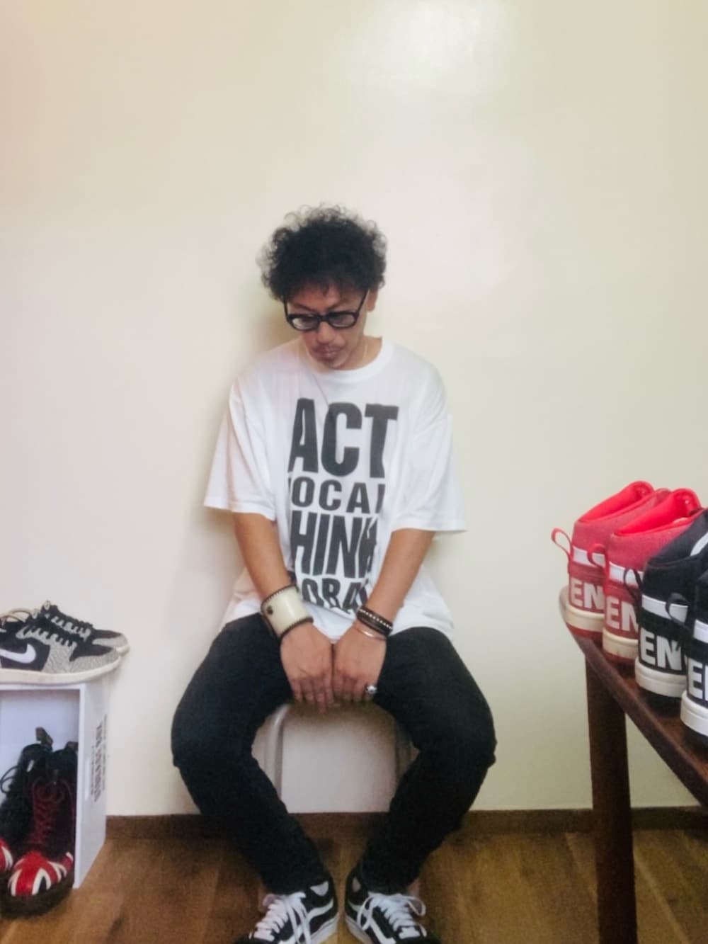 ブラック系のデニムパンツ、ブラック系のスニーカー、ホワイト系のTシャツ/カットソーを着用したメンズの秋コーディネートの4枚目の写真