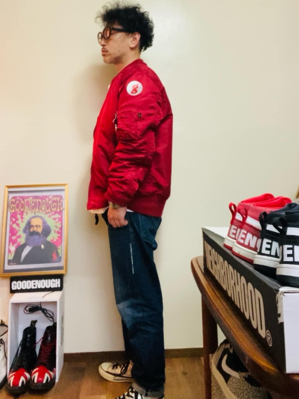 レッド系のMA-1、ブルー系のデニムパンツ、シルバー系のスニーカーを着用したメンズの春コーディネートの3枚目の写真