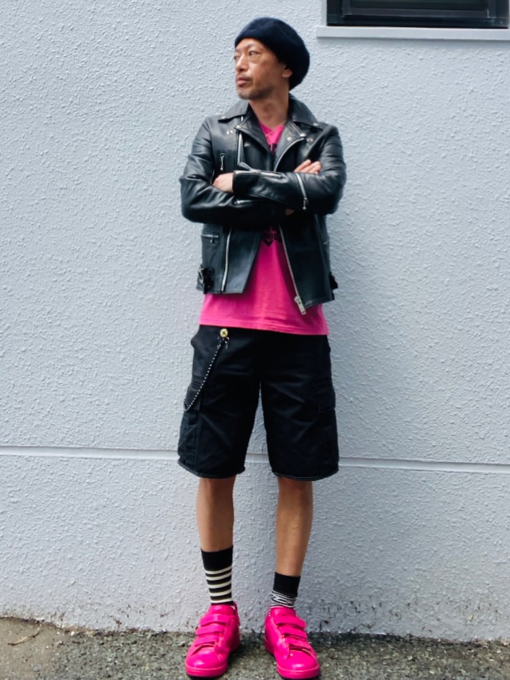 ブラック系のライダースジャケット、ピンク系のTシャツ/カットソー、ブラック系のカーゴパンツを着用したメンズの春コーディネートの3枚目の写真