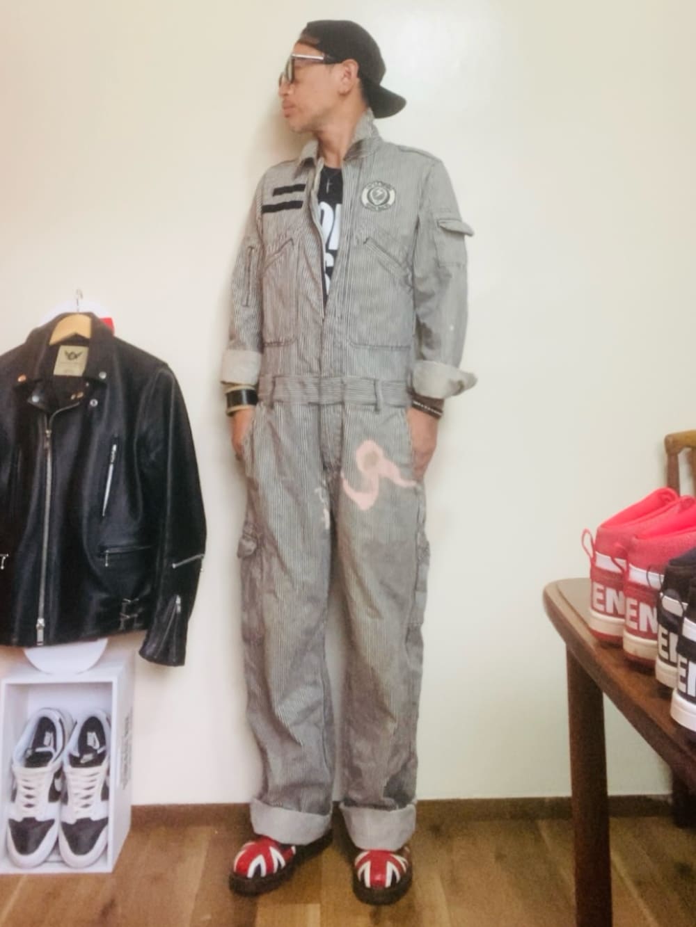 グレー系のつなぎ/オールインワン、ブラック系のブーツ、ブラック系のキャップを着用したメンズの秋コーディネートの2枚目の写真