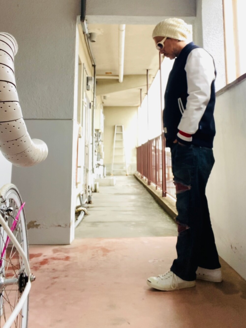 ブラック系のスタジャン、ブルー系のデニムパンツ、ホワイト系のスニーカーを着用したメンズの冬コーディネートの4枚目の写真