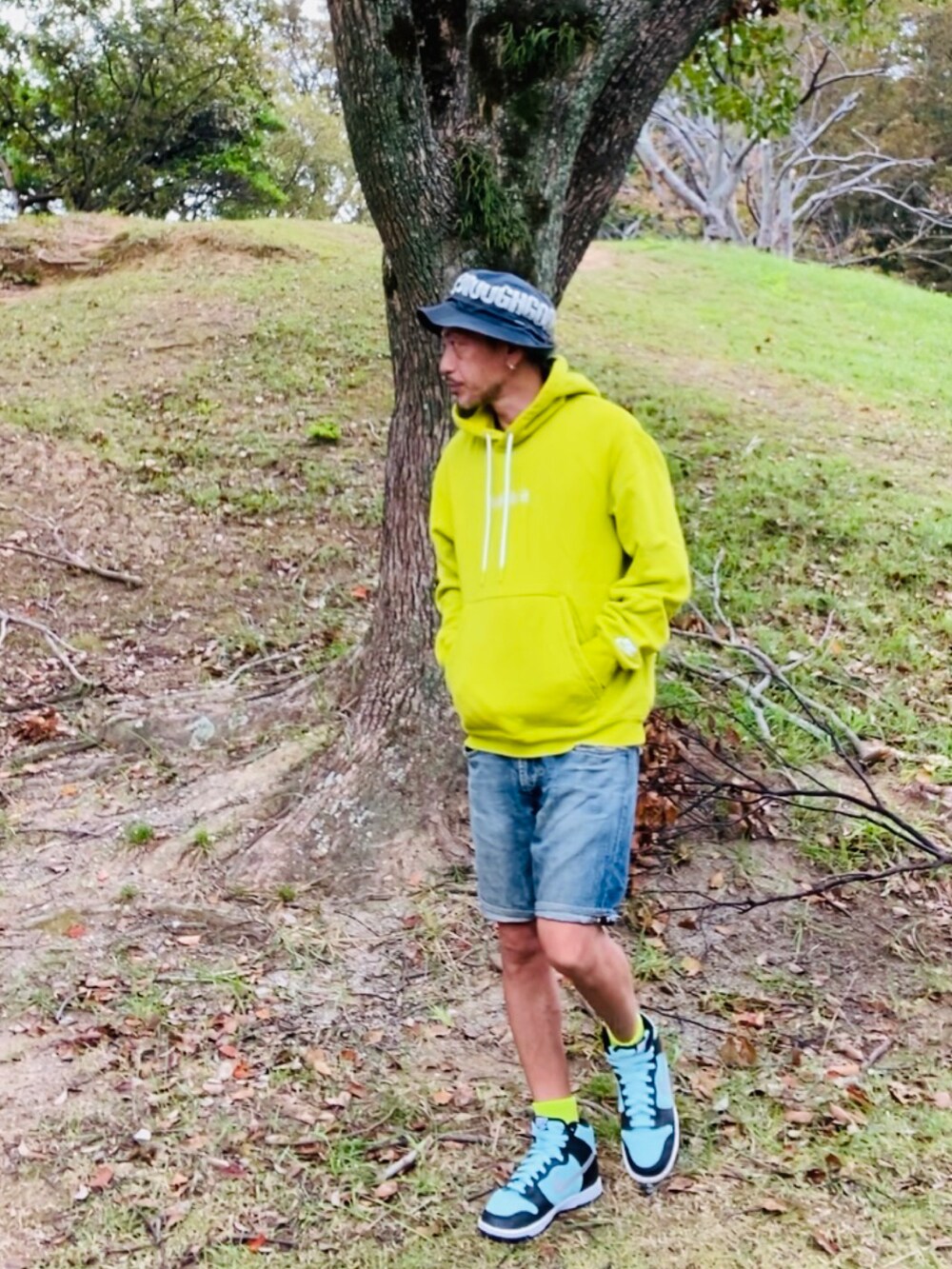 イエロー系のパーカー、ブルー系のその他パンツ、グリーン系のスニーカーを着用したメンズの秋コーディネートの3枚目の写真