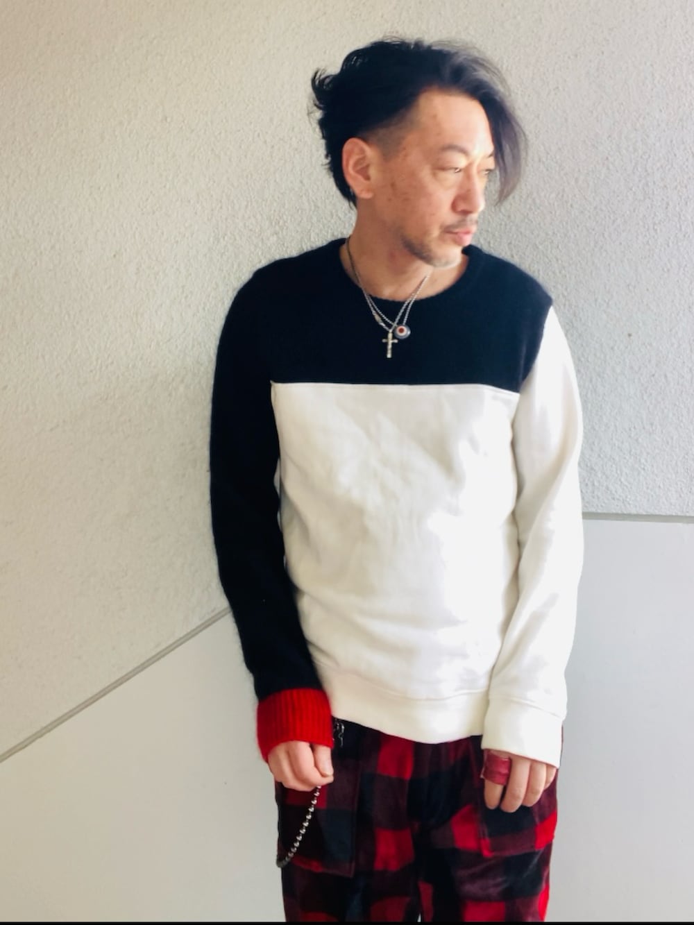 ブラック系のニット/セーター、レッド系のその他パンツ、レッド系のブーツを着用したメンズの春コーディネートの2枚目の写真