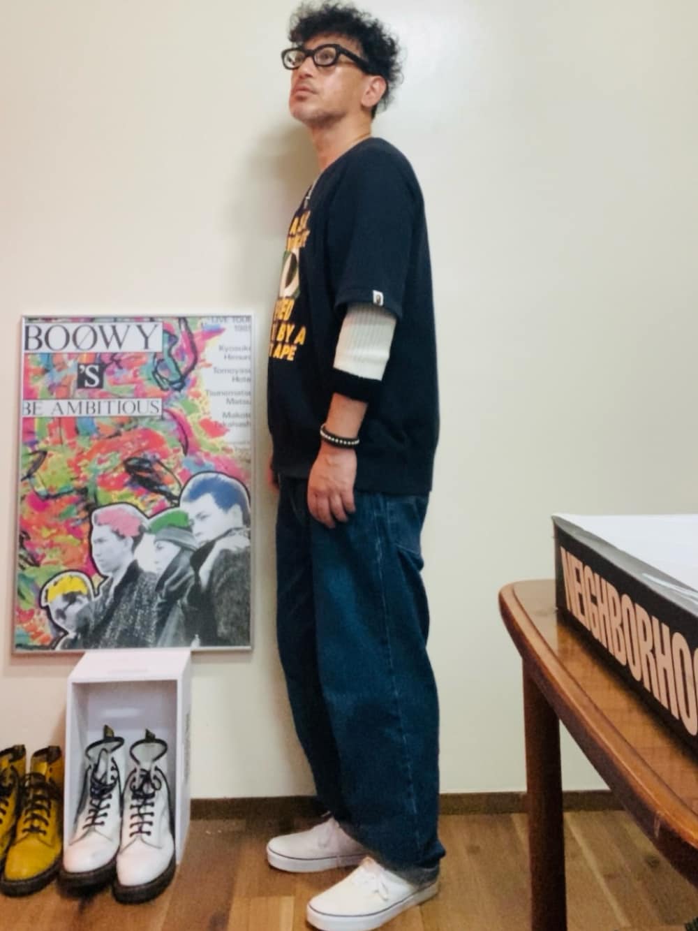 ブラック系のスウェット、ブルー系のデニムパンツ、ホワイト系のスニーカーを着用したメンズの秋コーディネートの2枚目の写真