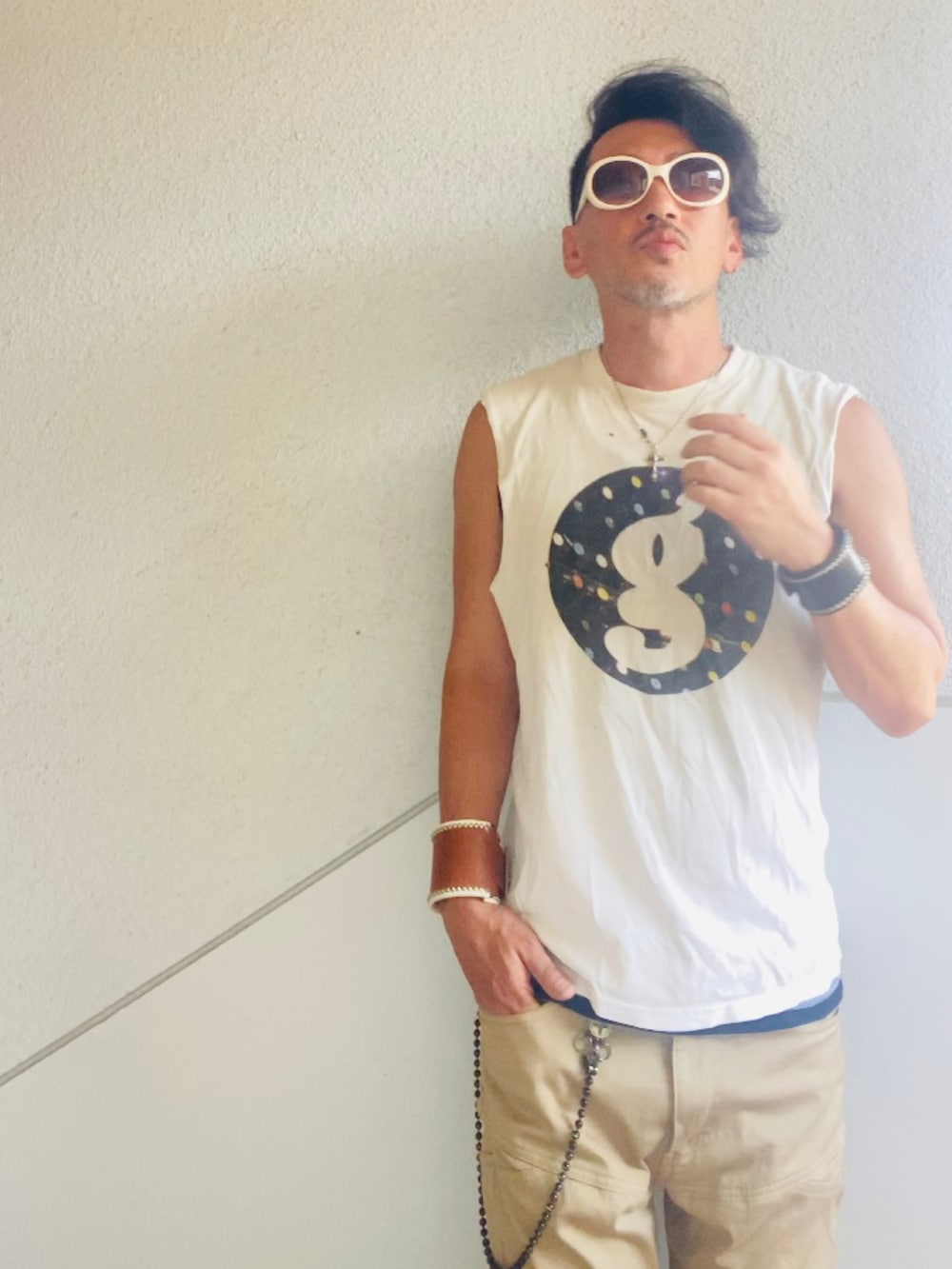 ホワイト系のTシャツ/カットソー、ベージュ系のチノパンツ、ブラック系のサンダルを着用したメンズの夏コーディネートの2枚目の写真