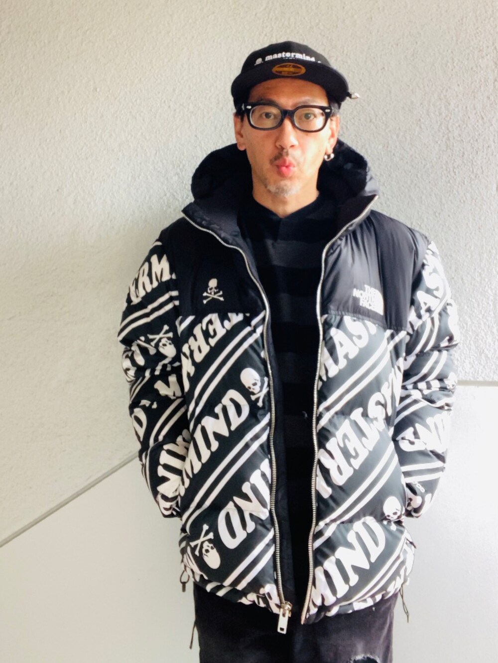 ブラック系のダウンジャケット/コート、グレー系のニット/セーター、ブラック系のその他パンツを着用したメンズの冬コーディネートの2枚目の写真