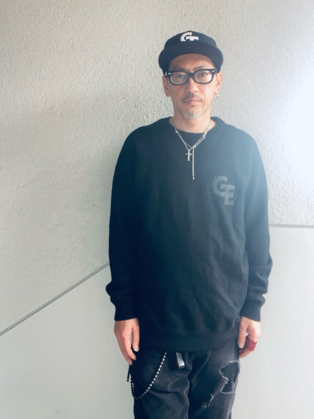 ブラック系のニット/セーター、ブラック系のその他パンツ、ブラック系のスニーカーを着用したメンズの春コーディネートの2枚目の写真