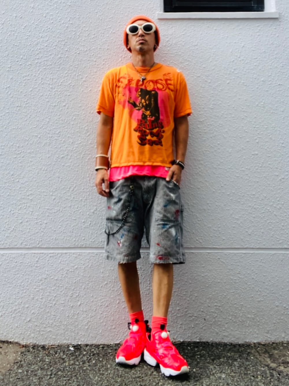 オレンジ系のTシャツ/カットソー、ピンク系のTシャツ/カットソー、グレー系のデニムパンツを着用したメンズの秋コーディネートの3枚目の写真