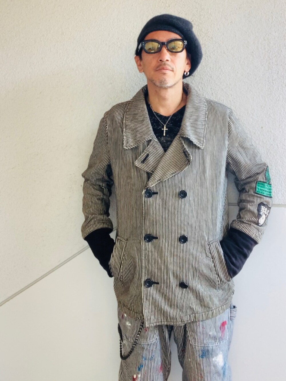 グレー系のピーコート、グレー系のデニムパンツ、ブラック系のブーツを着用したメンズの秋コーディネートの2枚目の写真