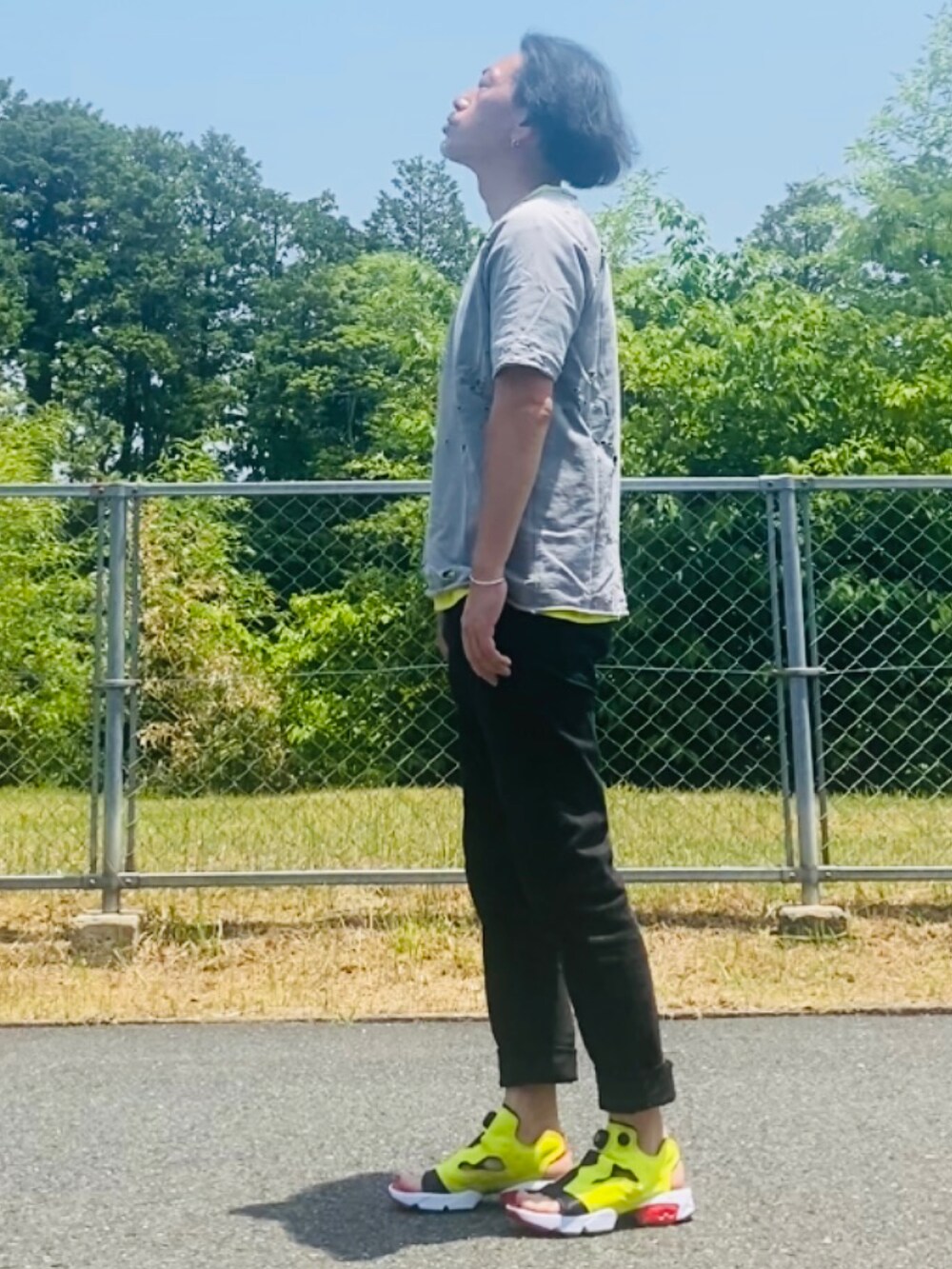 グレー系のTシャツ/カットソー、イエロー系のTシャツ/カットソー、ブラック系のデニムパンツを着用したメンズの夏コーディネートの4枚目の写真