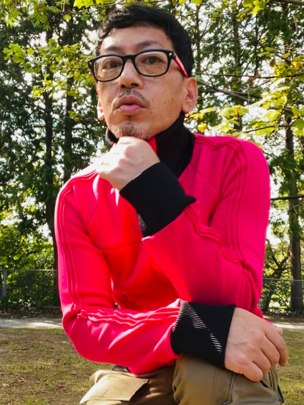 ピンク系のジャージ、グリーン系のカーゴパンツ、ピンク系のスニーカーを着用したメンズの秋コーディネートの3枚目の写真