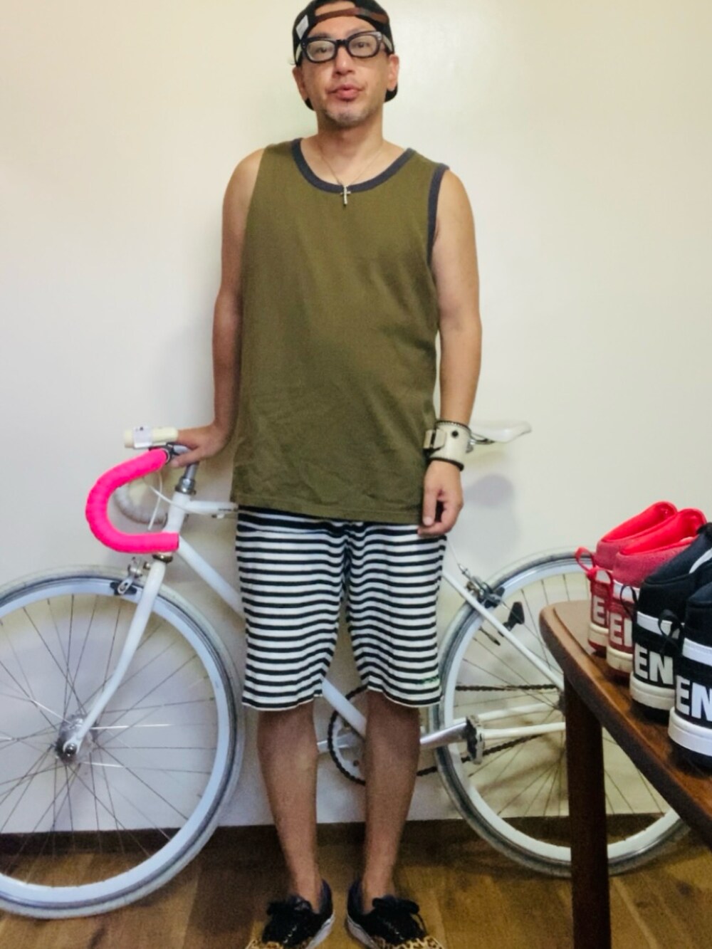 グリーン系のタンクトップ、グレー系のスウェットパンツ、ベージュ系のスニーカーを着用したメンズの夏コーディネートの4枚目の写真