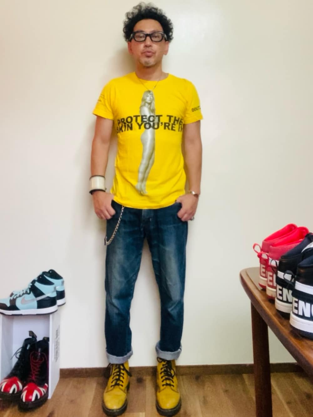 イエロー系のブーツ、イエロー系のTシャツ/カットソー、ブルー系のデニムパンツを着用したメンズの夏コーディネートの4枚目の写真
