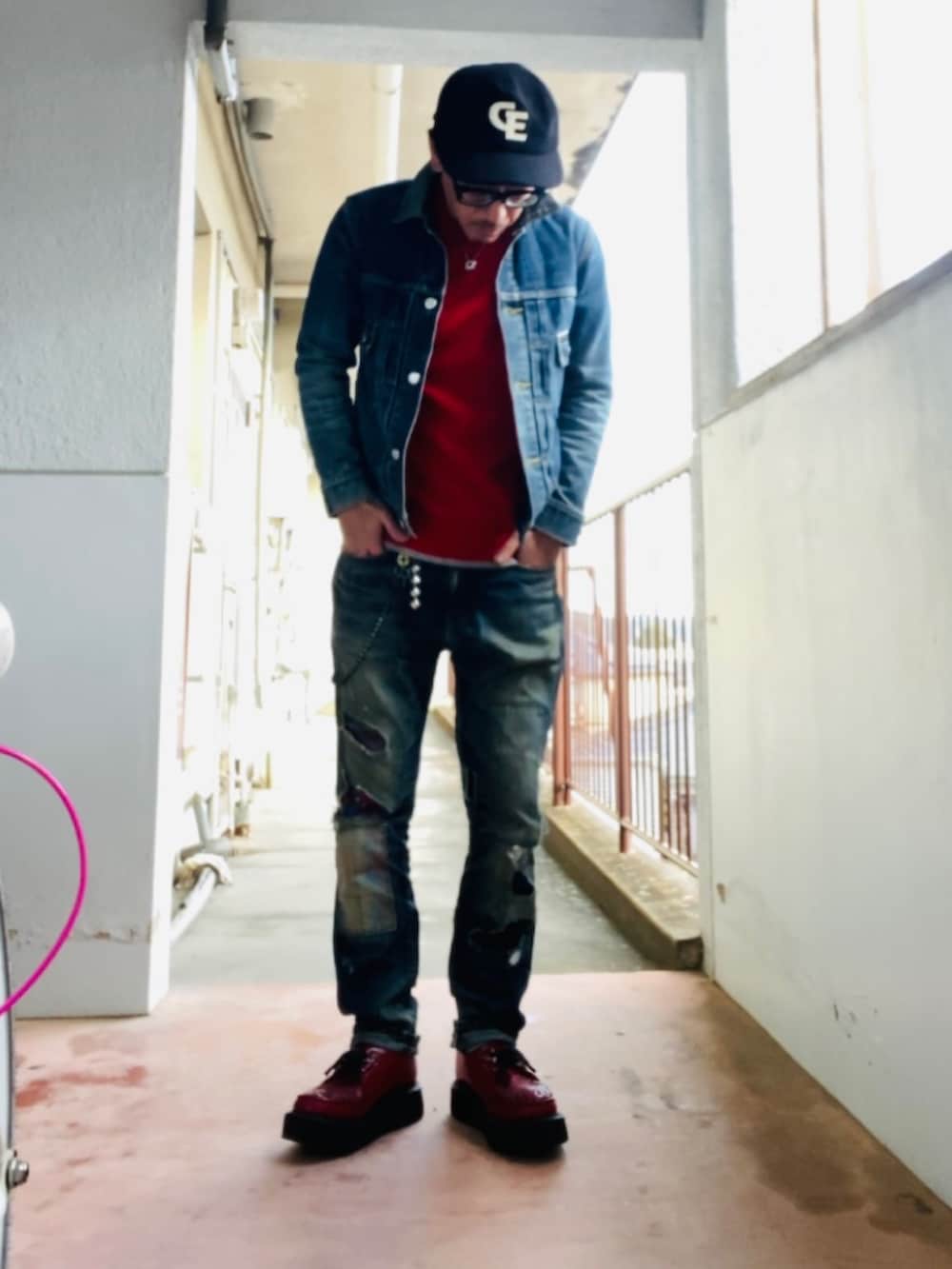 ブルー系のデニムジャケット、レッド系のニット/セーター、ブルー系のデニムパンツを着用したメンズの冬コーディネートの4枚目の写真