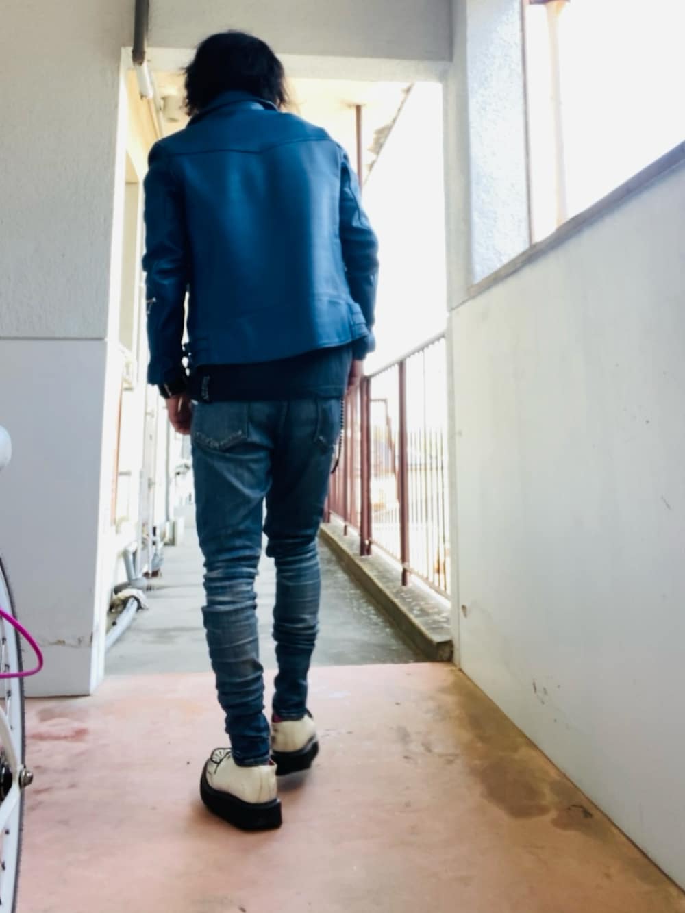 ブルー系のライダースジャケット、ブラック系のTシャツ/カットソー、ブルー系のデニムパンツを着用したメンズの春コーディネートの3枚目の写真