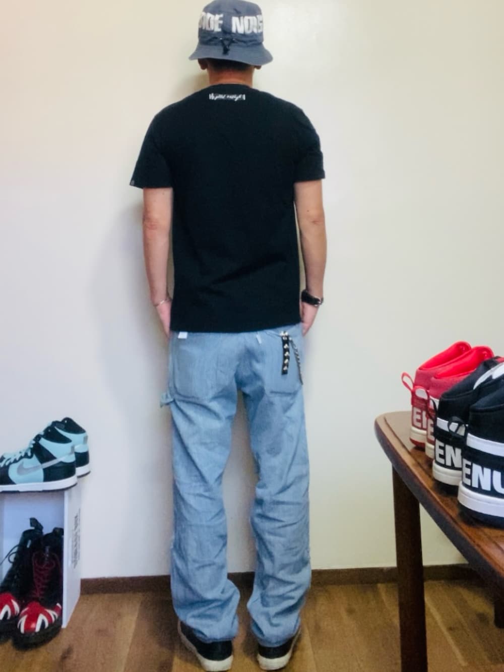 ブラック系のTシャツ/カットソー、ブルー系のデニムパンツ、ブラック系のスニーカーを着用したメンズの夏コーディネートの3枚目の写真