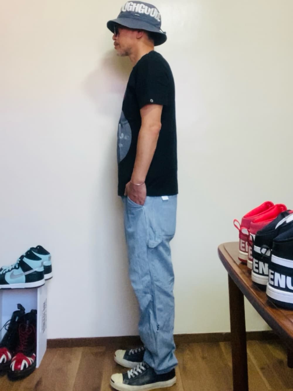 ブラック系のTシャツ/カットソー、ブルー系のデニムパンツ、ブラック系のスニーカーを着用したメンズの夏コーディネートの4枚目の写真