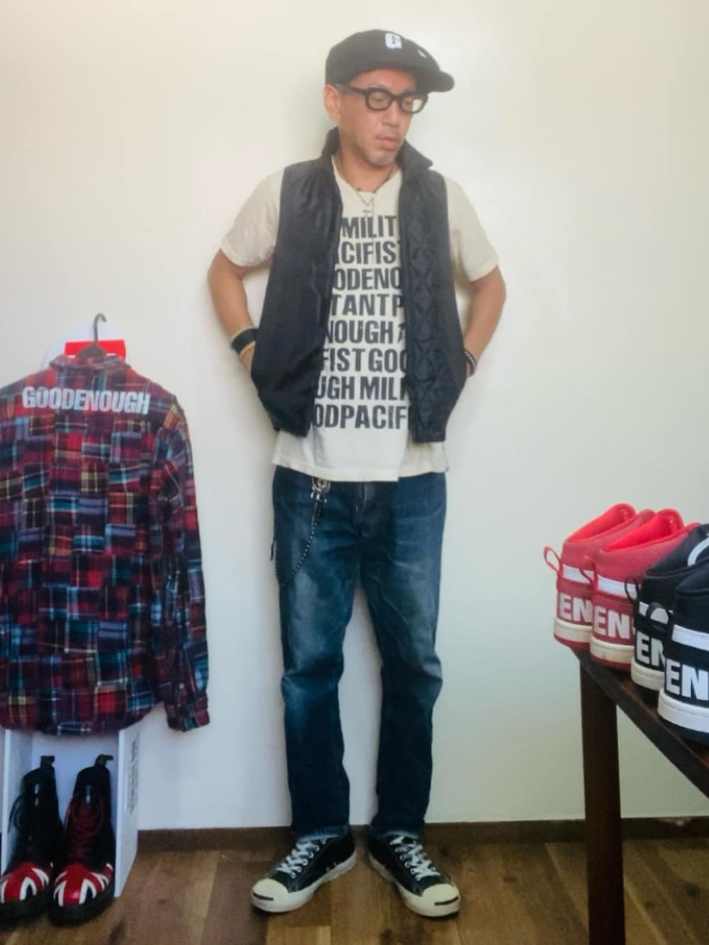 ベージュ系のTシャツ/カットソー、ブラック系のベスト、ブルー系のデニムパンツを着用したメンズの秋コーディネートの2枚目の写真