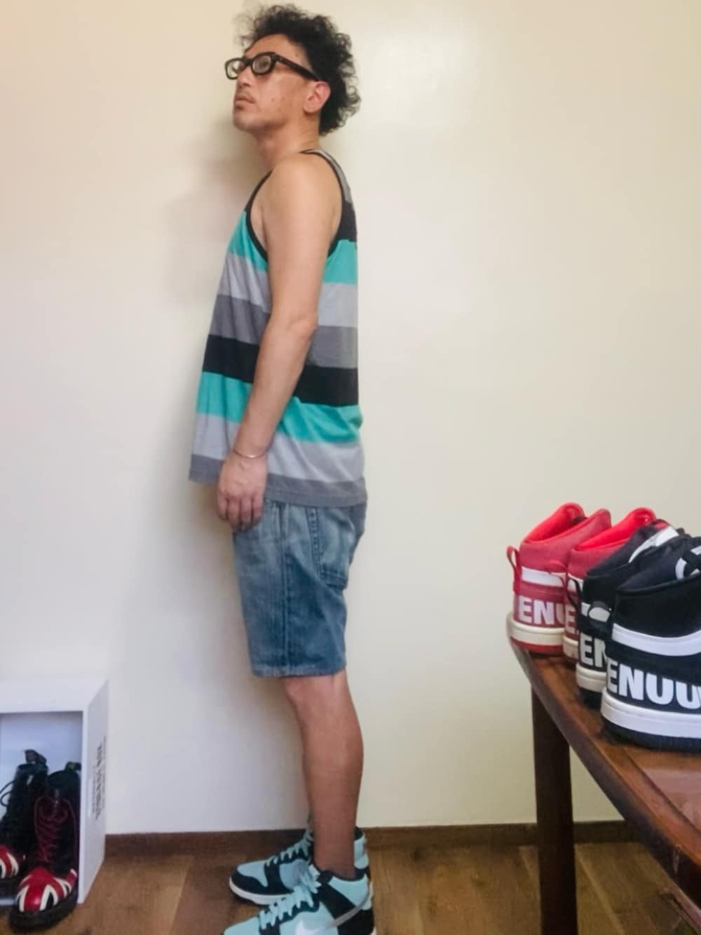 グリーン系のタンクトップ、グリーン系のスニーカー、ブルー系のその他パンツを着用したメンズの夏コーディネートの2枚目の写真