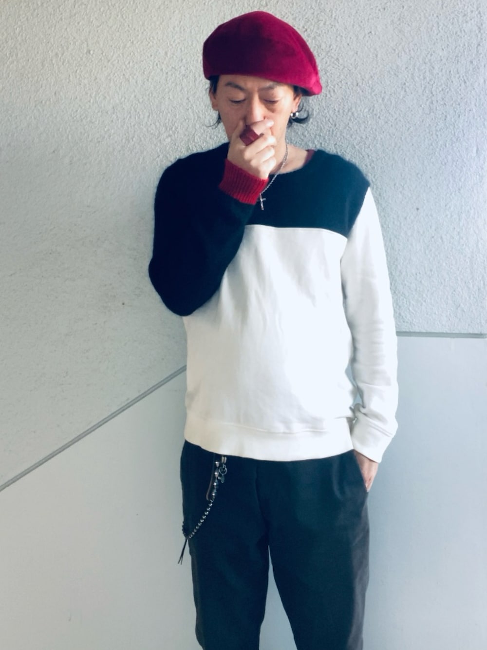 ブラック系のニット/セーター、ブラック系のチノパンツ、レッド系のブーツを着用したメンズの春コーディネートの5枚目の写真