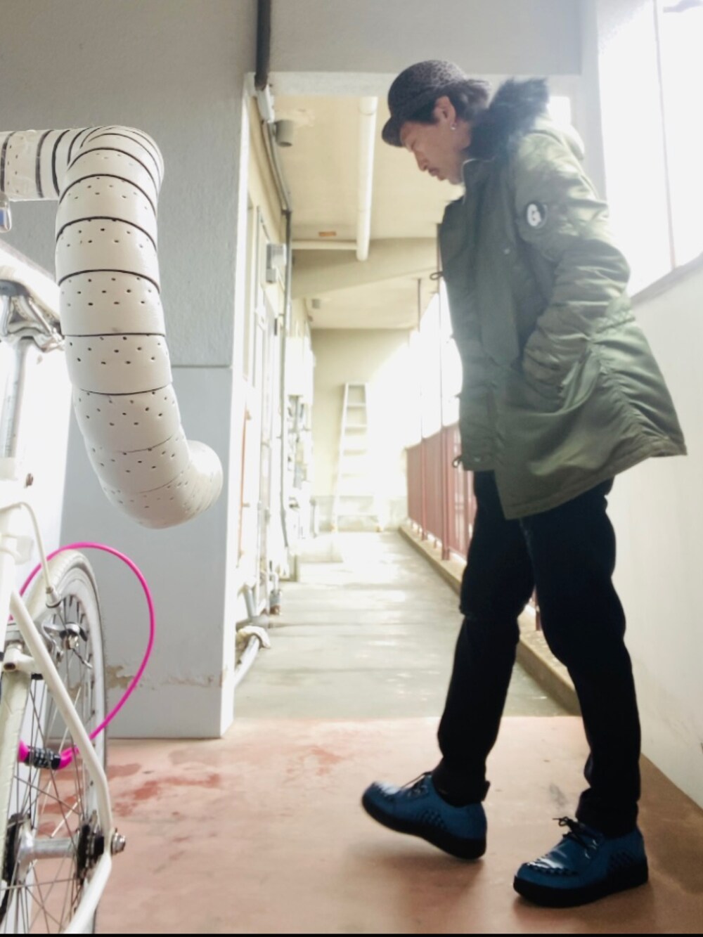 グリーン系のミリタリージャケット、グレー系のニット/セーター、ブラック系のその他パンツを着用したメンズの冬コーディネートの3枚目の写真