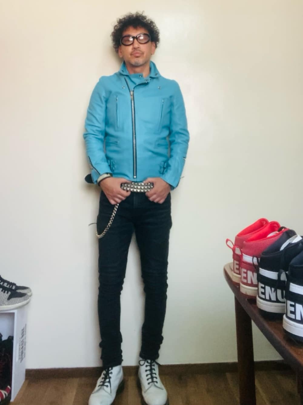 ブルー系のライダースジャケット、ブラック系のデニムパンツ、ホワイト系のブーツを着用したメンズの秋コーディネートの2枚目の写真