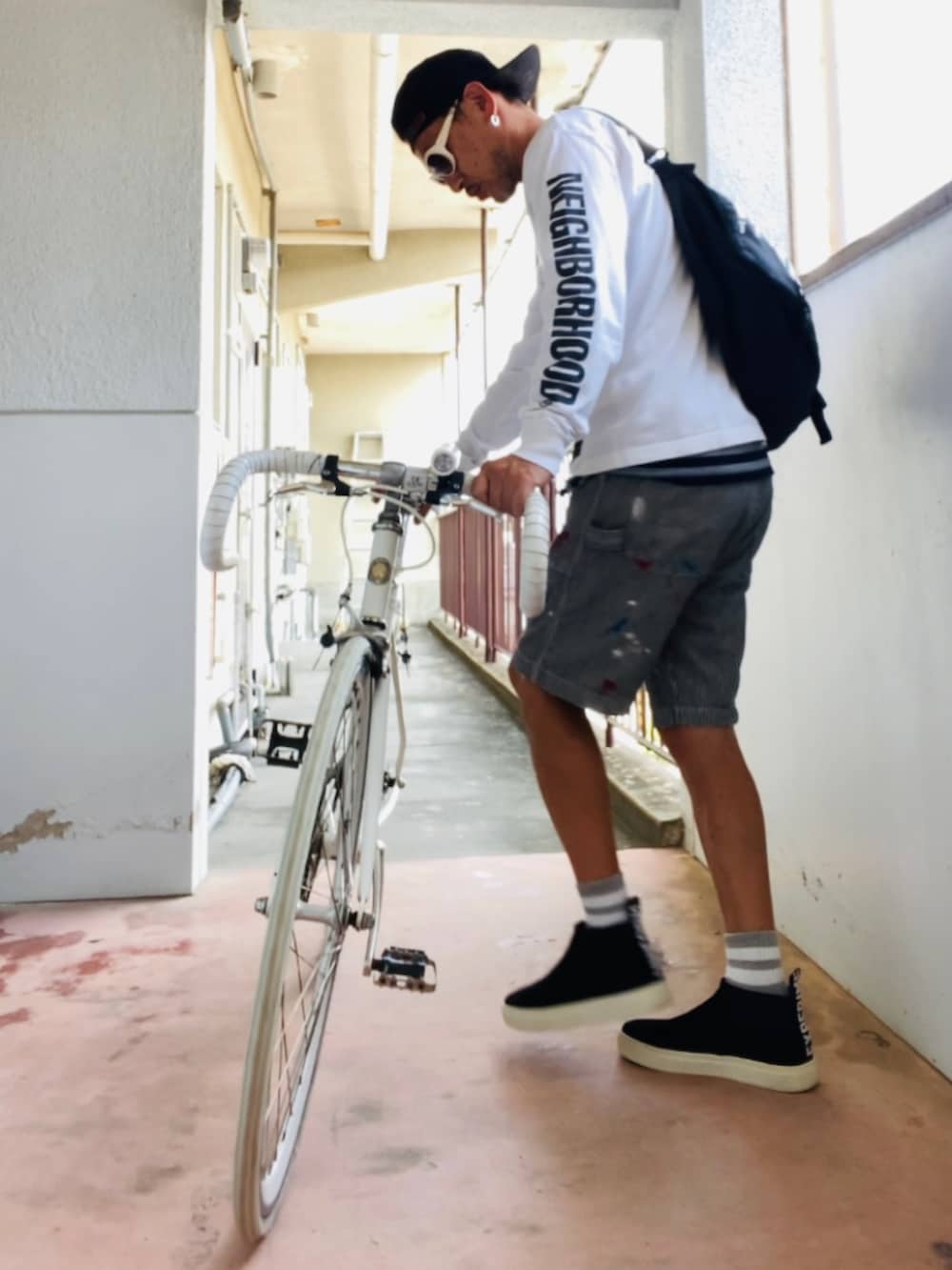 ホワイト系のTシャツ/カットソー、ブラック系のメッセンジャーバッグ、グレー系のデニムパンツを着用したメンズの秋コーディネートの4枚目の写真