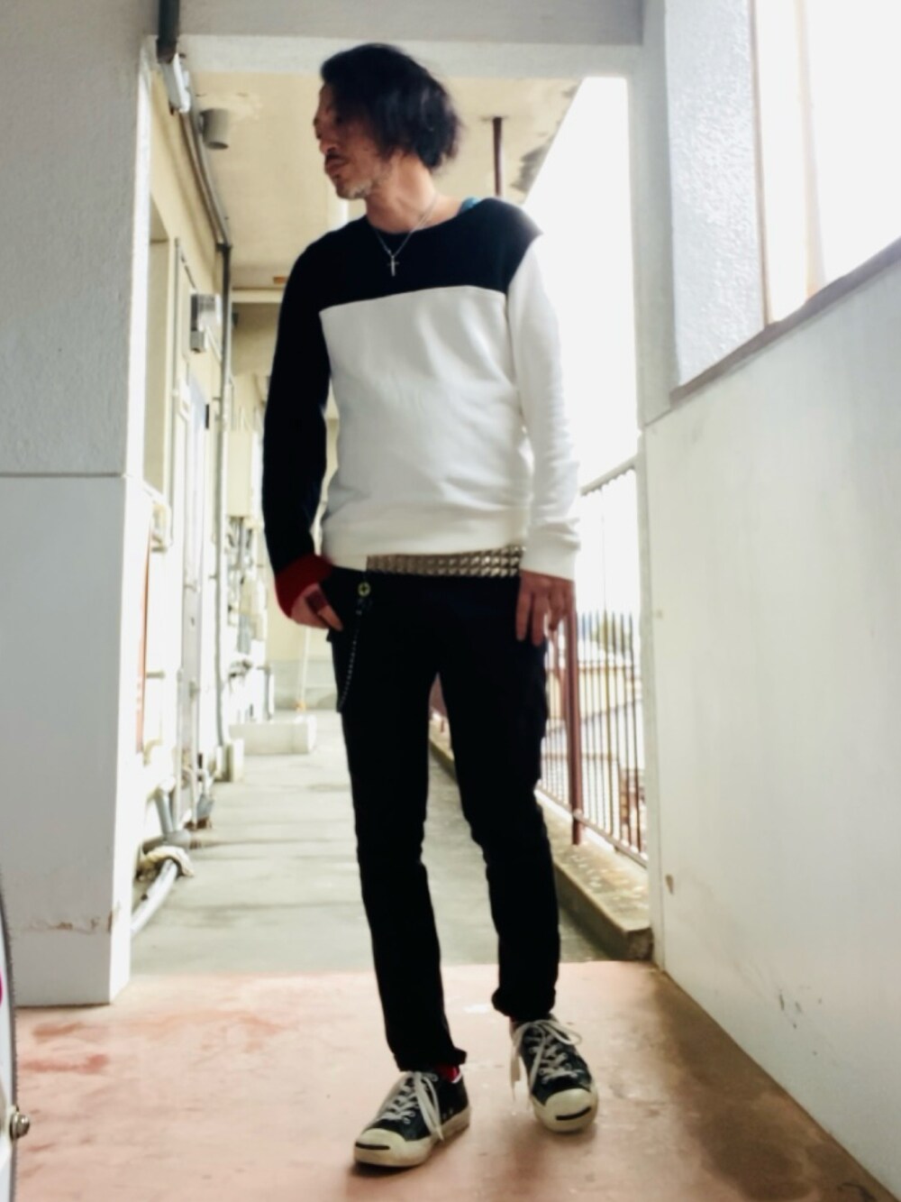 ブラック系のニット/セーター、ブラック系のパンツ、ブラック系のスニーカーを着用したメンズの春コーディネートの3枚目の写真