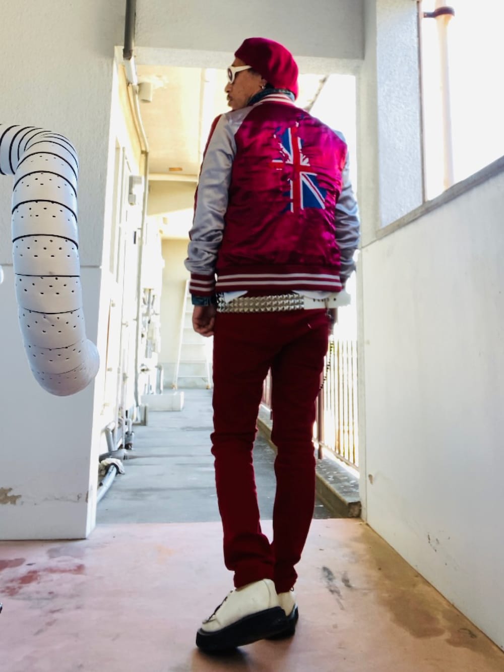 レッド系のスカジャン、ホワイト系のTシャツ/カットソー、レッド系のデニムパンツを着用したメンズの秋コーディネートの3枚目の写真