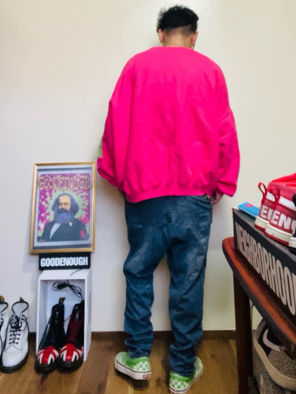 ピンク系のスウェット、ブルー系のデニムパンツ、グリーン系のスリッポンを着用したメンズの春コーディネートの2枚目の写真