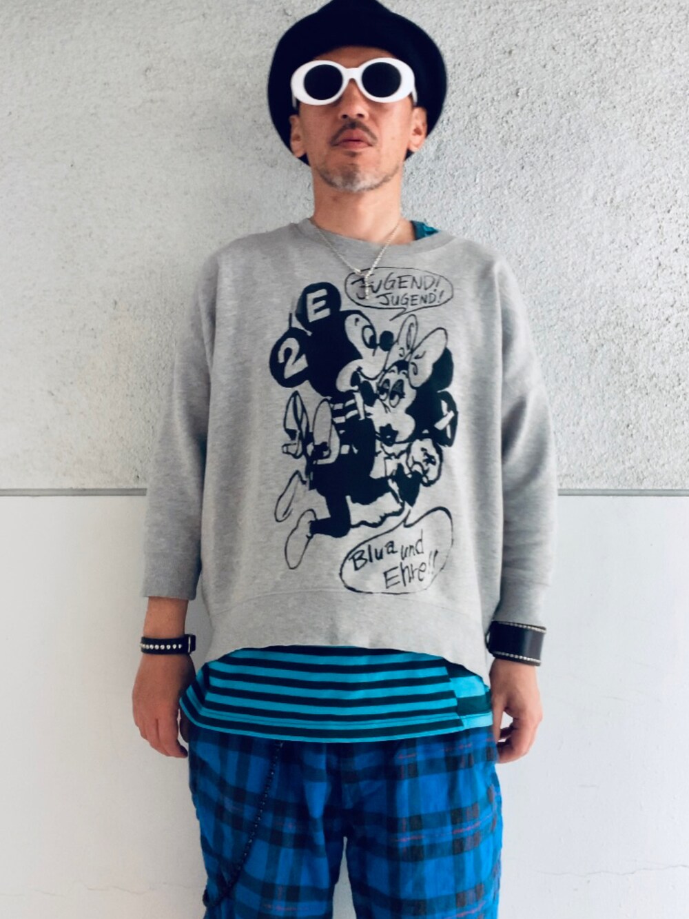 グレー系のスウェット、ブルー系のタンクトップ、ブルー系のその他パンツを着用したメンズの春コーディネートの2枚目の写真