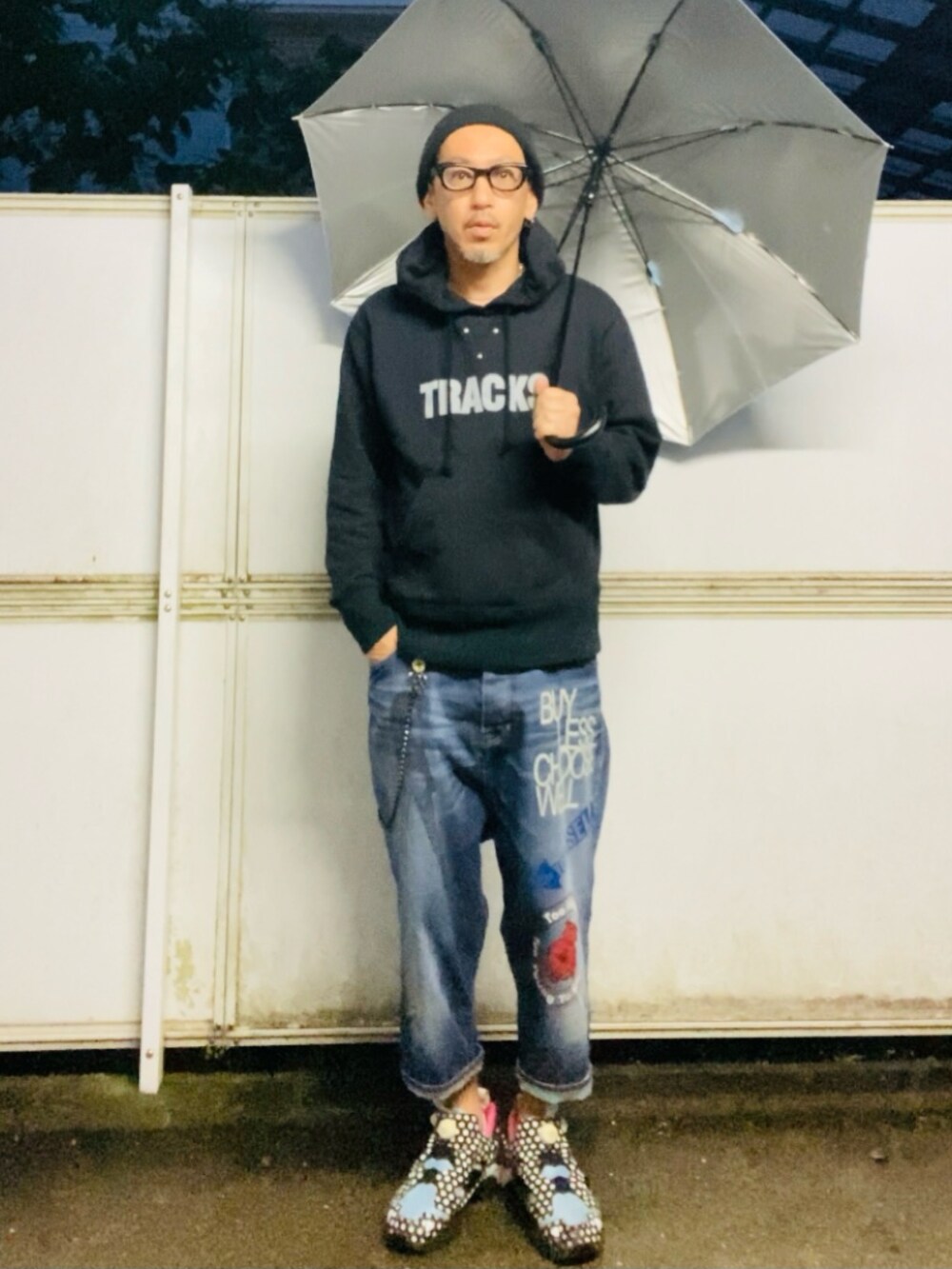 ブラック系のパーカー、ブルー系のデニムパンツ、ブラック系のスニーカーを着用したメンズの春コーディネートの4枚目の写真