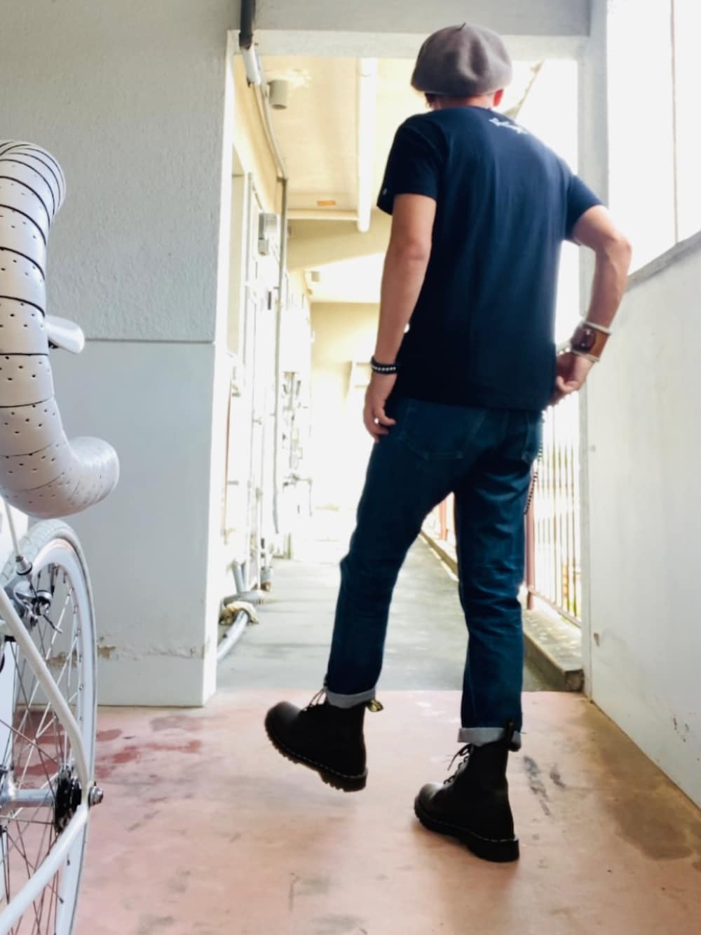 ブラック系のTシャツ/カットソー、ブルー系のデニムパンツ、グリーン系のブーツを着用したメンズの秋コーディネートの3枚目の写真
