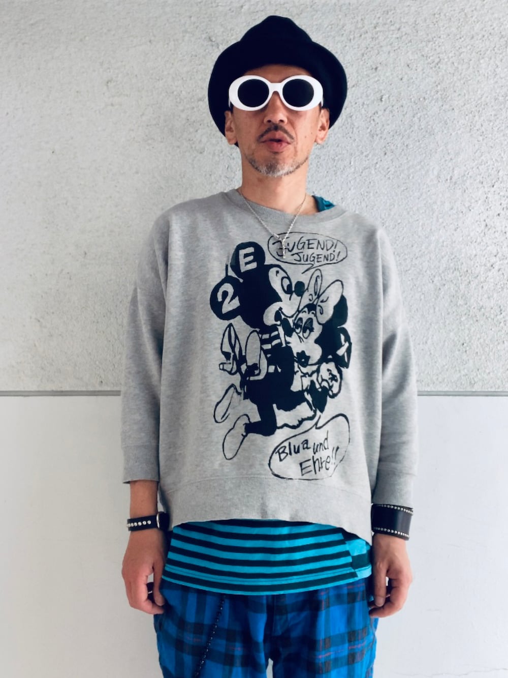 グレー系のスウェット、ブルー系のタンクトップ、ブルー系のその他パンツを着用したメンズの春コーディネートの4枚目の写真