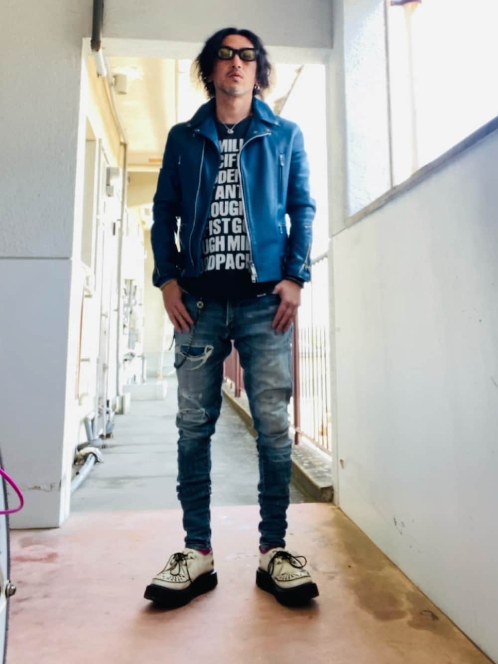 ブルー系のライダースジャケット、ブラック系のTシャツ/カットソー、ブルー系のデニムパンツを着用したメンズの春コーディネートの5枚目の写真