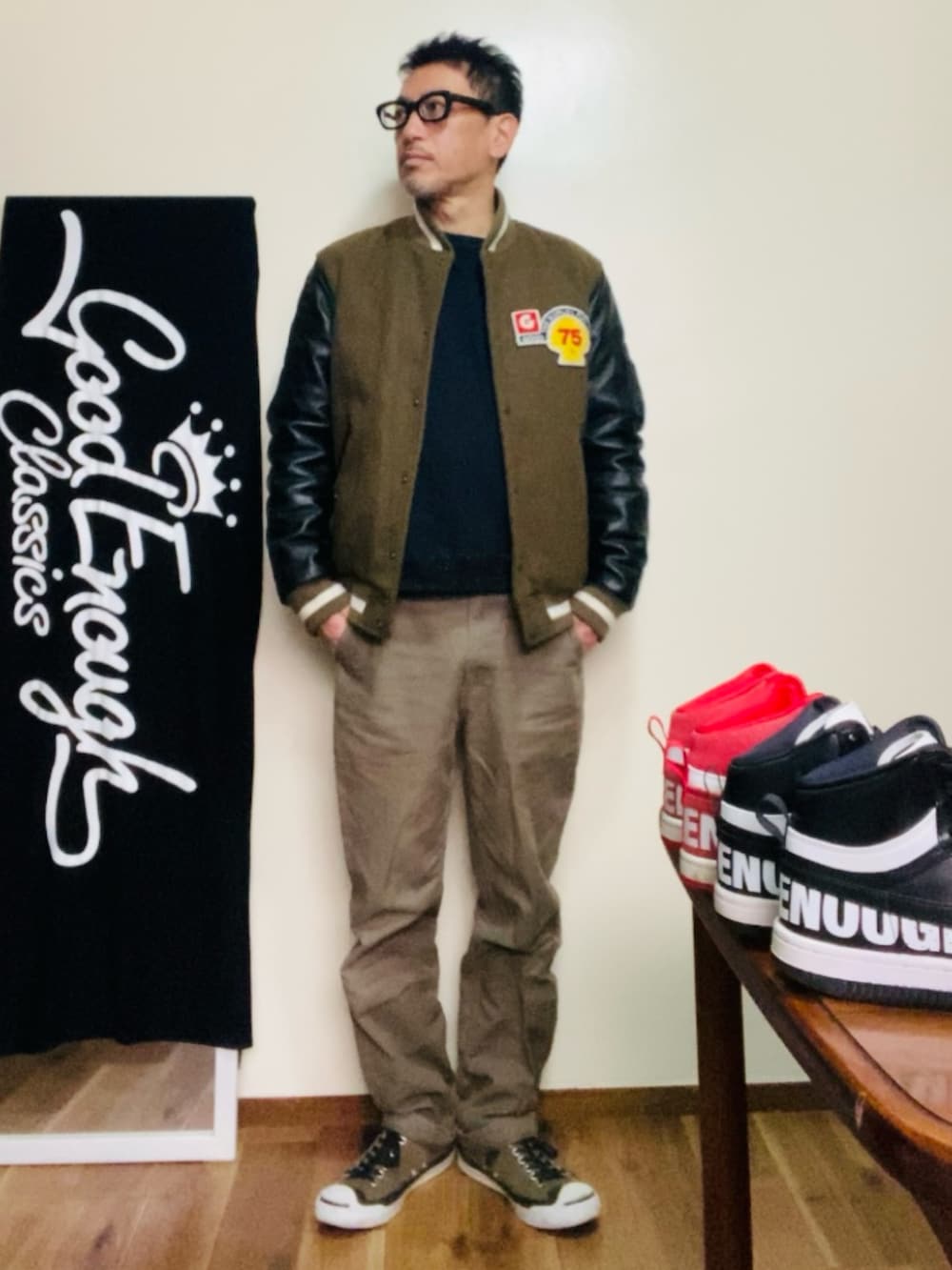 グリーン系のスタジャン、ブラック系のスウェット、グリーン系のカーゴパンツを着用したメンズの冬コーディネートの2枚目の写真