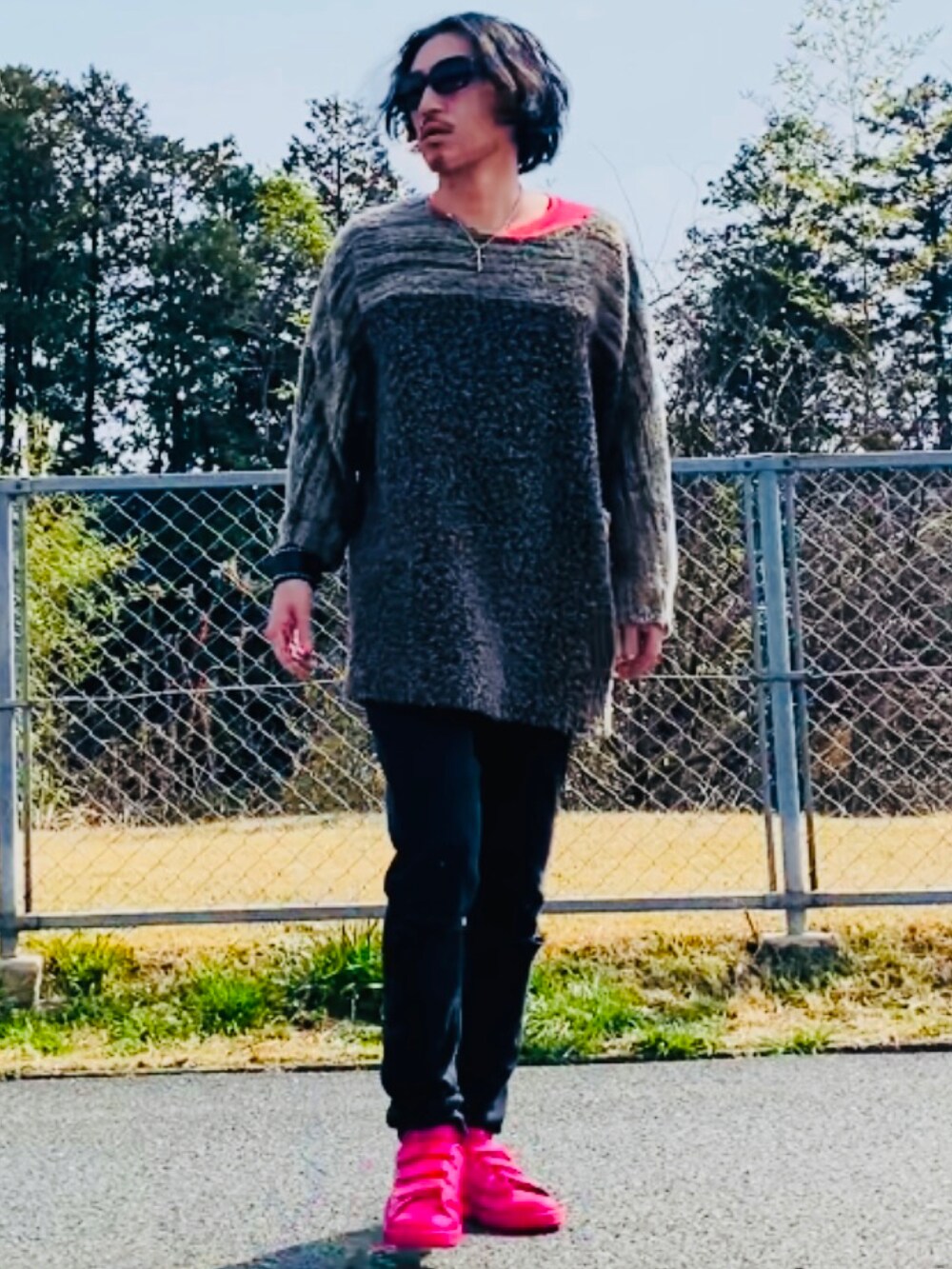 ブラウン系のニット/セーター、ピンク系のTシャツ/カットソー、ブラック系のデニムパンツを着用したメンズの春コーディネートの2枚目の写真