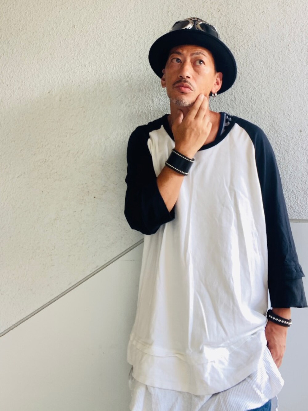 ブルー系のデニムパンツ、ブラック系のスニーカー、ブラック系のショルダーバッグを着用したメンズの夏コーディネートの2枚目の写真