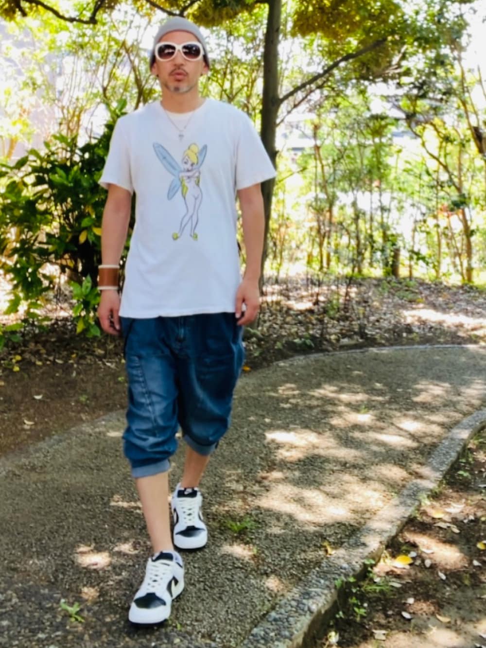 ホワイト系のTシャツ/カットソー、ブルー系のデニムパンツ、ホワイト系のスニーカーを着用したメンズの春コーディネートの2枚目の写真