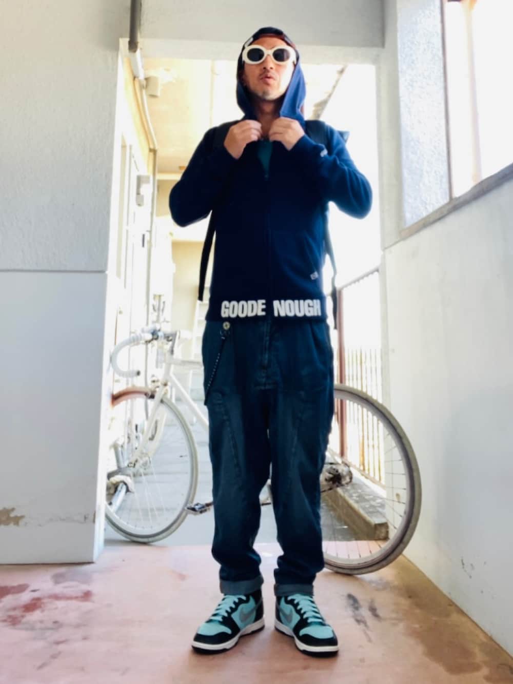 ブルー系のパーカー、ブルー系のデニムパンツ、ブラック系のバックパック/リュックを着用したメンズの秋コーディネートの3枚目の写真